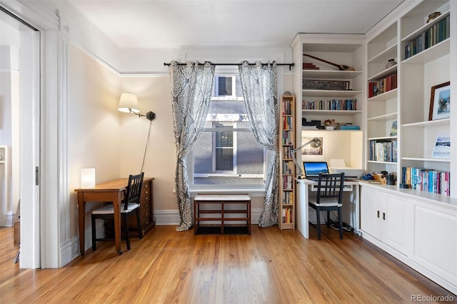 office space with light wood finished floors and built in desk