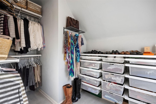 spacious closet with carpet flooring and vaulted ceiling