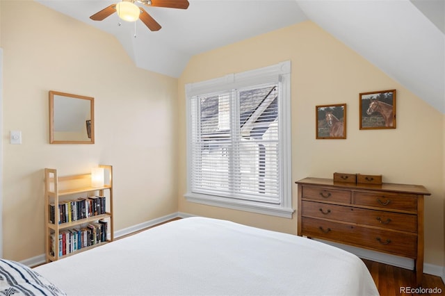 bedroom featuring lofted ceiling, dark wood finished floors, baseboards, and ceiling fan