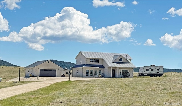 1970 County Road 241, Westcliffe, CO 81252 - view of front of property featuring dirt driveway, a front lawn, an attached garage, a mountain view, and stone siding