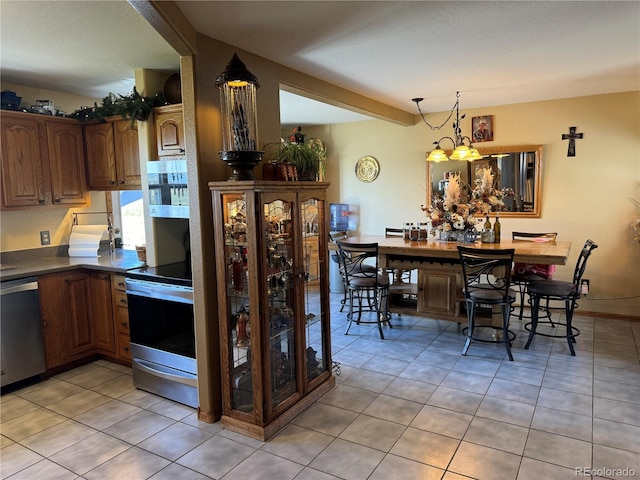 1970 County Road 241, Westcliffe, CO 81252 - kitchen featuring stainless steel appliances, a chandelier, light tile patterned floors, dark countertops, and decorative light fixtures
