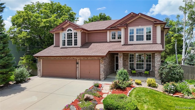 2521 Otter Ct, Lafayette, CO 80026 - craftsman-style home with driveway, an attached garage, a shingled roof, stone siding, and a porch