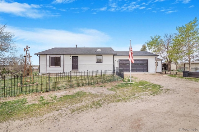 single story home with a garage, dirt driveway, and a fenced front yard