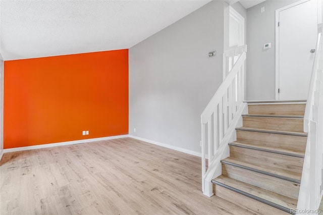 stairway featuring baseboards and wood finished floors
