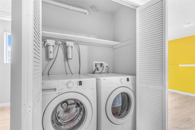 laundry room with separate washer and dryer, baseboards, laundry area, and wood finished floors