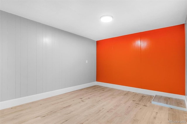 unfurnished room featuring baseboards and wood finished floors