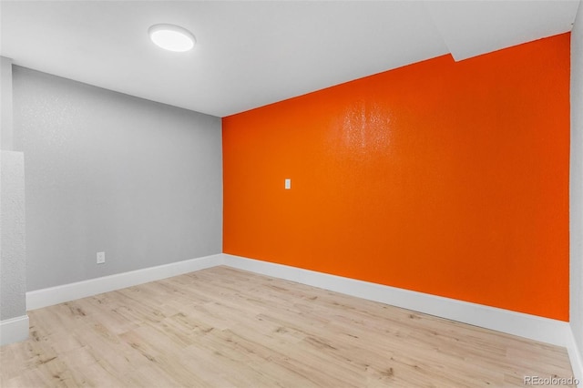unfurnished room with baseboards and wood finished floors