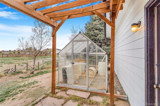 view of greenhouse featuring fence