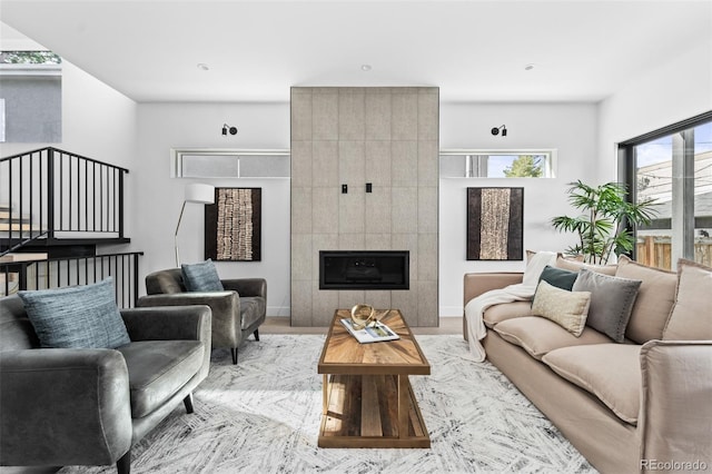 living room with tile walls, light hardwood / wood-style flooring, and a tiled fireplace