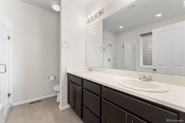 bathroom with tile patterned flooring, vanity, toilet, and a shower with shower door