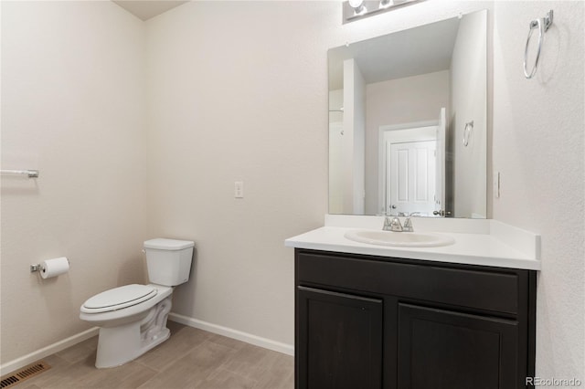 bathroom with wood-type flooring, toilet, and vanity