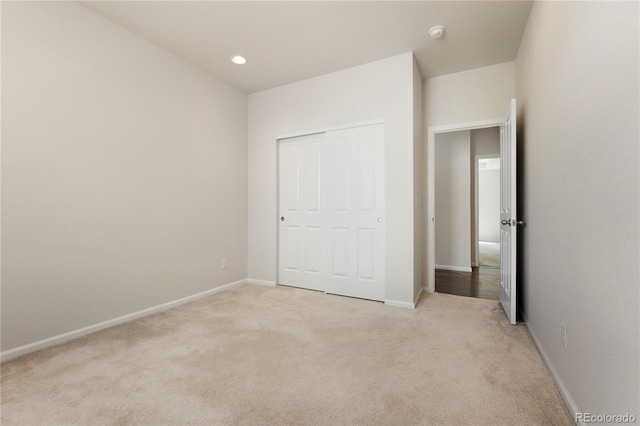 unfurnished bedroom with a closet and light carpet