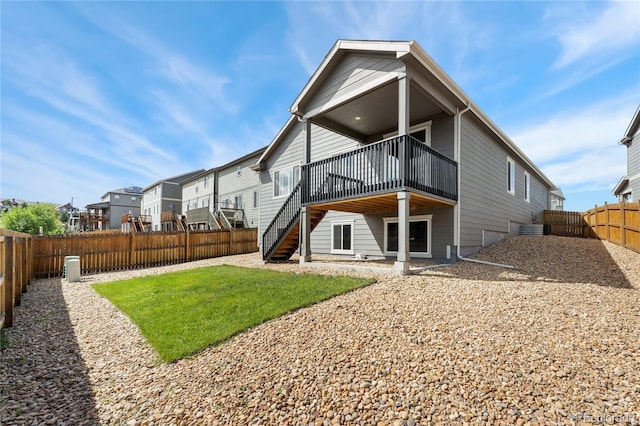 rear view of property with a deck and a lawn