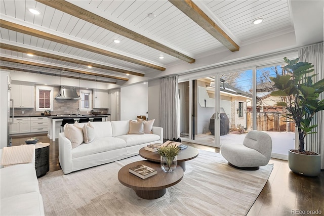 living room featuring beamed ceiling, recessed lighting, and light wood-style floors