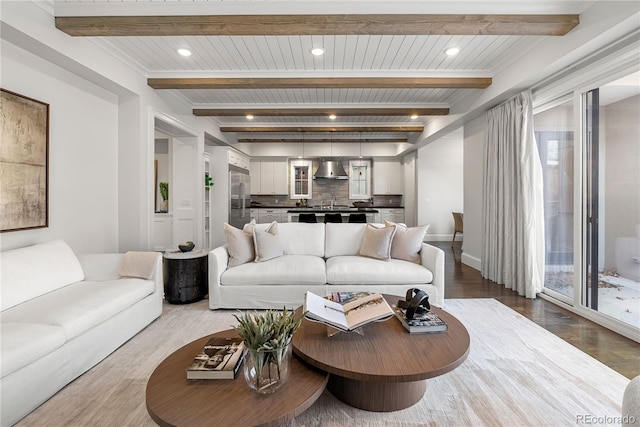 living area with recessed lighting, beam ceiling, and wood finished floors