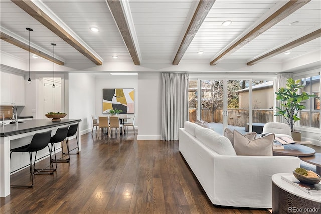 living room with recessed lighting, dark wood finished floors, beam ceiling, and baseboards