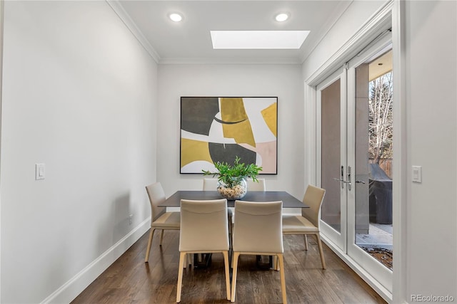 dining area with a skylight, baseboards, ornamental molding, french doors, and dark wood finished floors