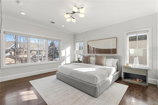 bedroom with baseboards, dark wood-style flooring, visible vents, and crown molding