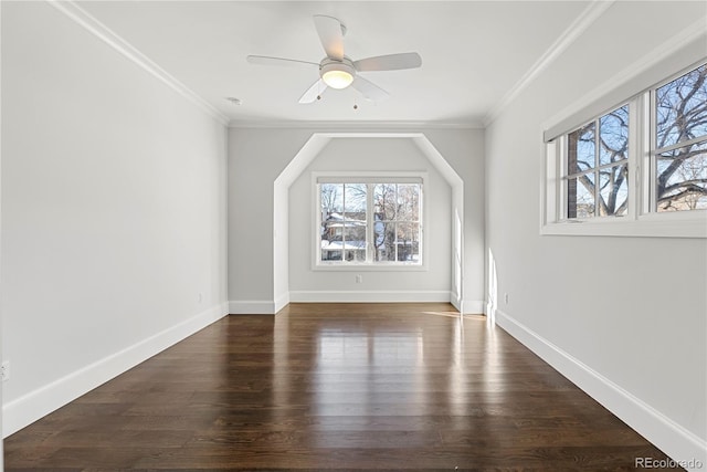 bonus room with dark wood finished floors, a ceiling fan, and baseboards