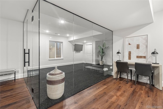 bathroom with baseboards, wood finished floors, and recessed lighting