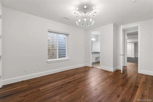 unfurnished bedroom featuring dark wood-type flooring, visible vents, a notable chandelier, and baseboards