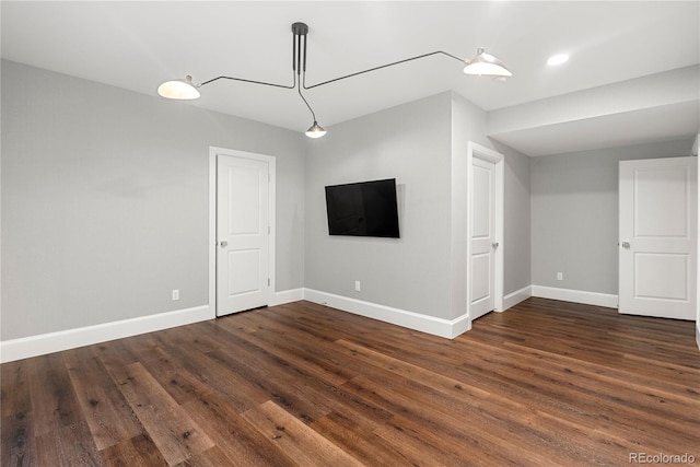 unfurnished living room with dark wood-style floors and baseboards