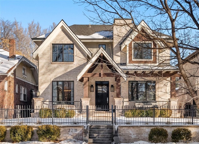 view of front of house featuring a fenced front yard, brick siding, and a chimney