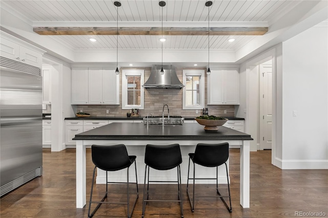 2218 S Clayton St, Denver, CO 80210 - kitchen with stainless steel built in fridge, wall chimney range hood, dark countertops, backsplash, and beam ceiling