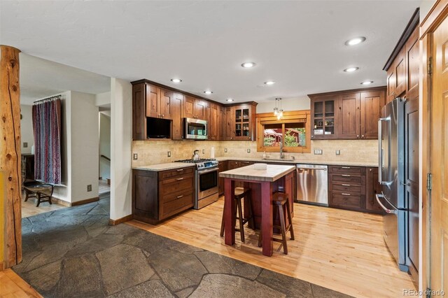 403 Pitkin St, Frisco, CO 80443 - kitchen with stainless steel appliances, light countertops, a center island, recessed lighting, and glass insert cabinets