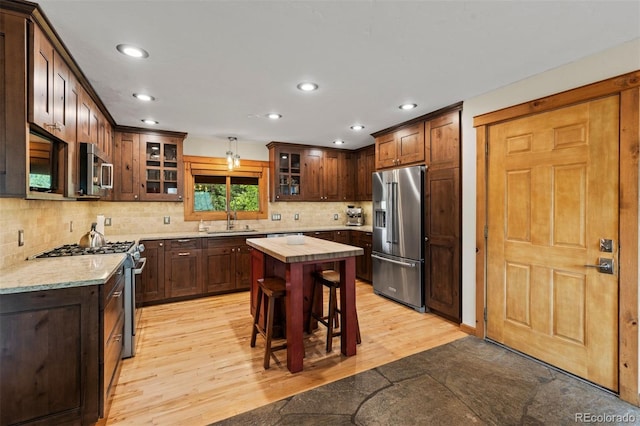 403 Pitkin St, Frisco, CO 80443 - kitchen featuring stainless steel appliances, recessed lighting, glass insert cabinets, light wood-type flooring, and backsplash