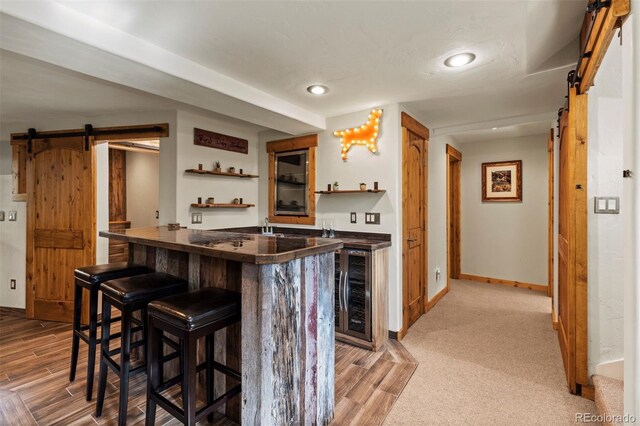403 Pitkin St, Frisco, CO 80443 - indoor wet bar with a barn door, beverage cooler, light wood finished floors, and recessed lighting