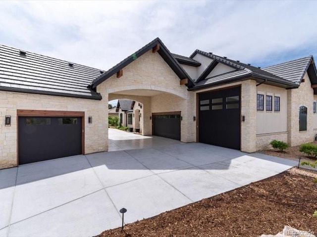 860 Diamond Ridge Cir, Castle Rock, CO 80108 - view of front facade featuring stone siding, driveway, a garage, and a tiled roof