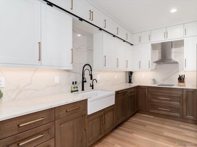 860 Diamond Ridge Cir, Castle Rock, CO 80108 - kitchen with wall chimney exhaust hood, white cabinetry, tasteful backsplash, light wood finished floors, and recessed lighting