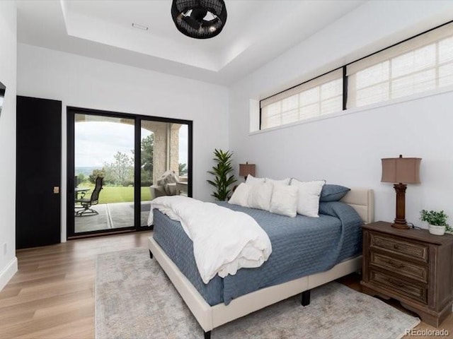 860 Diamond Ridge Cir, Castle Rock, CO 80108 - bedroom with access to outside, light wood-style flooring, a tray ceiling, and baseboards