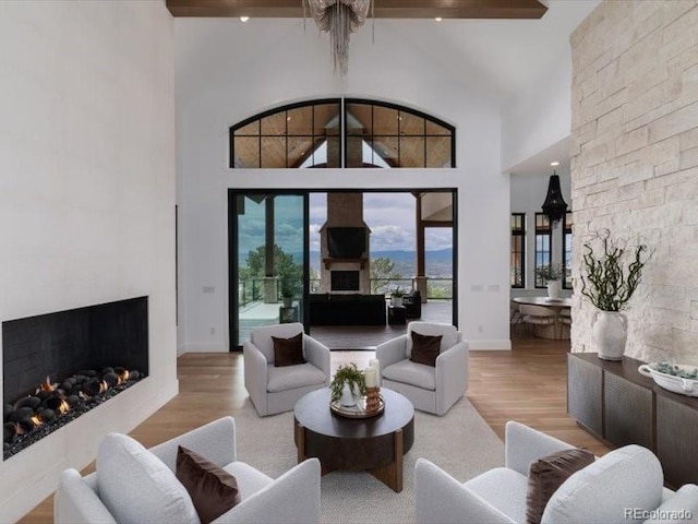 860 Diamond Ridge Cir, Castle Rock, CO 80108 - living room featuring a warm lit fireplace, wood finished floors, a high ceiling, and baseboards