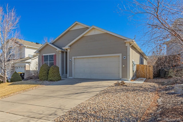 view of front facade featuring a garage, driveway, and fence