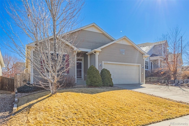 view of front of property with a front lawn, fence, driveway, and an attached garage