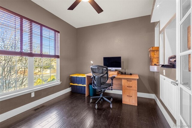 home office with dark wood-style floors, a ceiling fan, visible vents, and baseboards