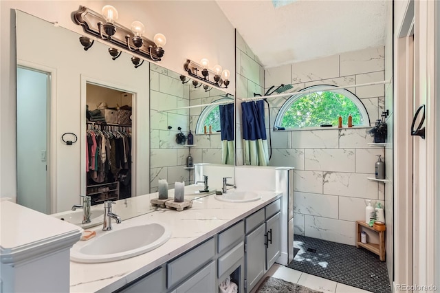 9492 Crestmore Way, Highlands Ranch, CO 80126 - bathroom with double vanity, walk in shower, tile patterned floors, a spacious closet, and tile walls