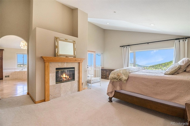 carpeted bedroom featuring a fireplace and a high ceiling