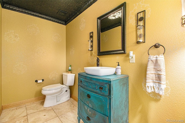 bathroom with tile patterned flooring, vanity, ornamental molding, and toilet