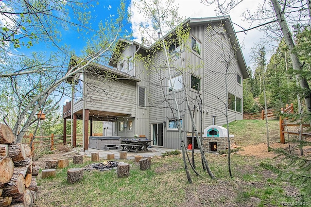 rear view of property featuring a hot tub