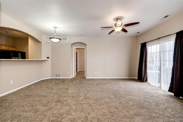 carpeted empty room featuring ceiling fan