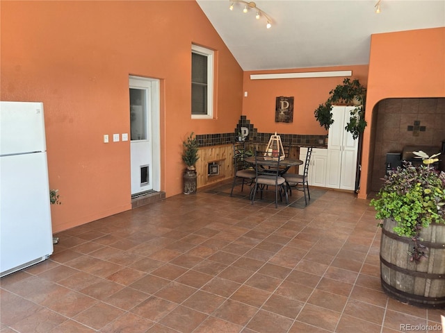 148 15th St, Burlington, CO 80807 - dining space with high vaulted ceiling, track lighting, and dark tile patterned flooring