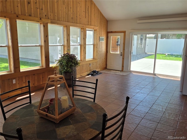 148 15th St, Burlington, CO 80807 - dining space featuring wood walls, stone tile floors, and lofted ceiling