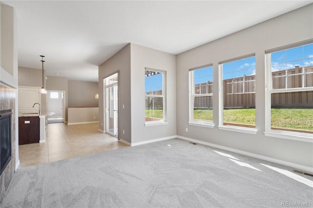 5895 S Taft Ct Unit H, Littleton, CO 80127 - unfurnished living room with baseboards, plenty of natural light, light colored carpet, and light tile patterned floors