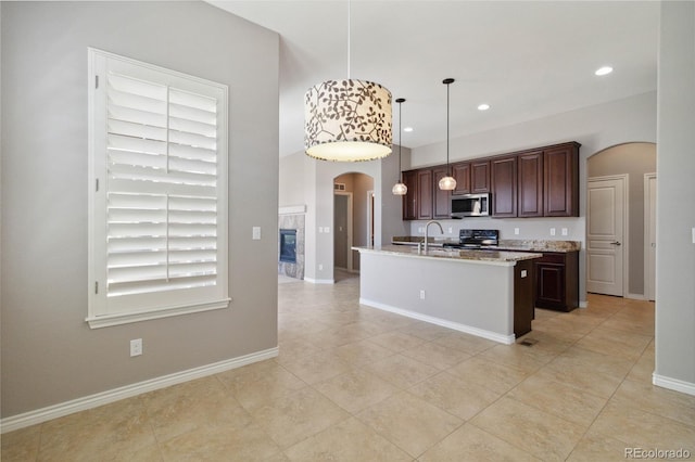 5895 S Taft Ct Unit H, Littleton, CO 80127 - kitchen featuring stainless steel microwave, arched walkways, range with electric stovetop, a sink, and light tile patterned floors