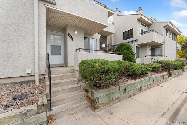 view of exterior entry with a balcony