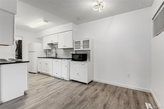 kitchen featuring sink, white cabinets, tasteful backsplash, and white appliances