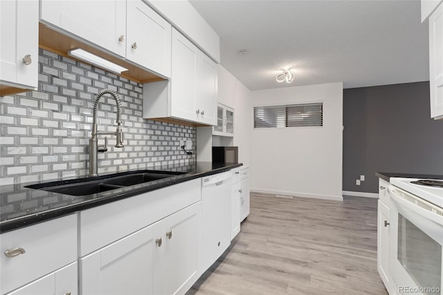 kitchen with white appliances, a textured ceiling, white cabinetry, decorative backsplash, and sink